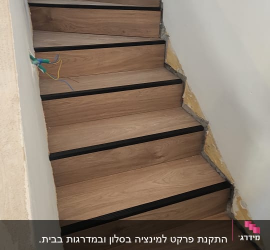 מדרגות עץ עם פרקט מותקן על הקירות